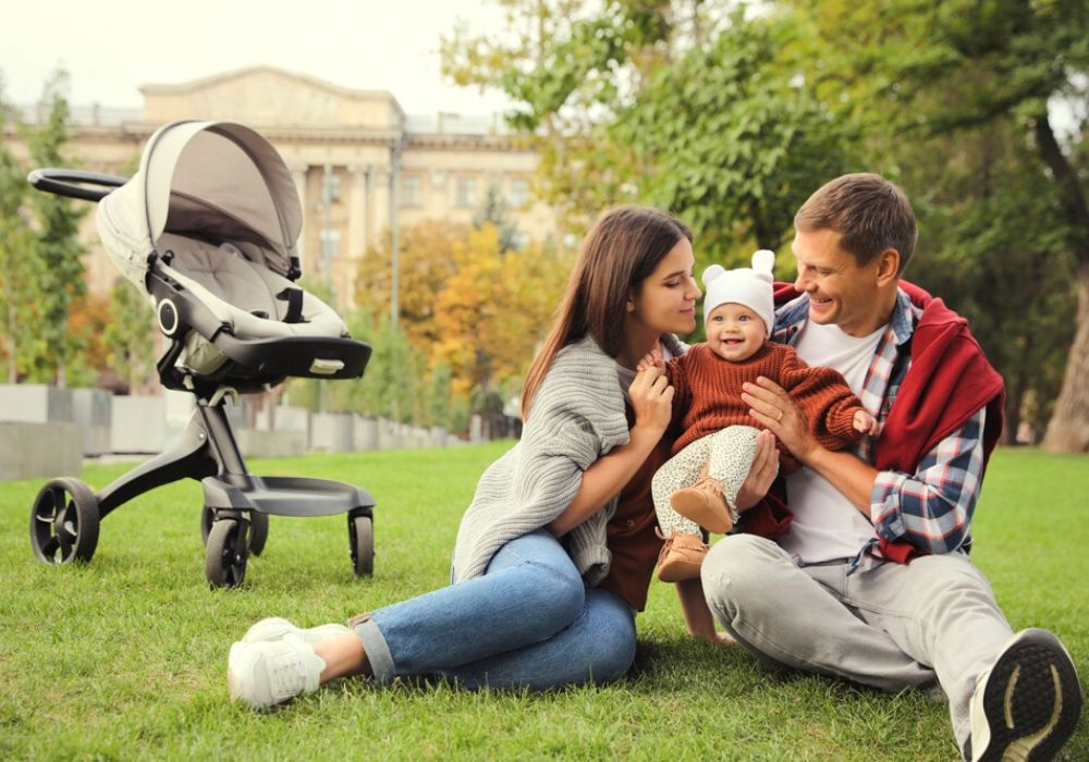 papa et maman au parc avec bébé dans les bras