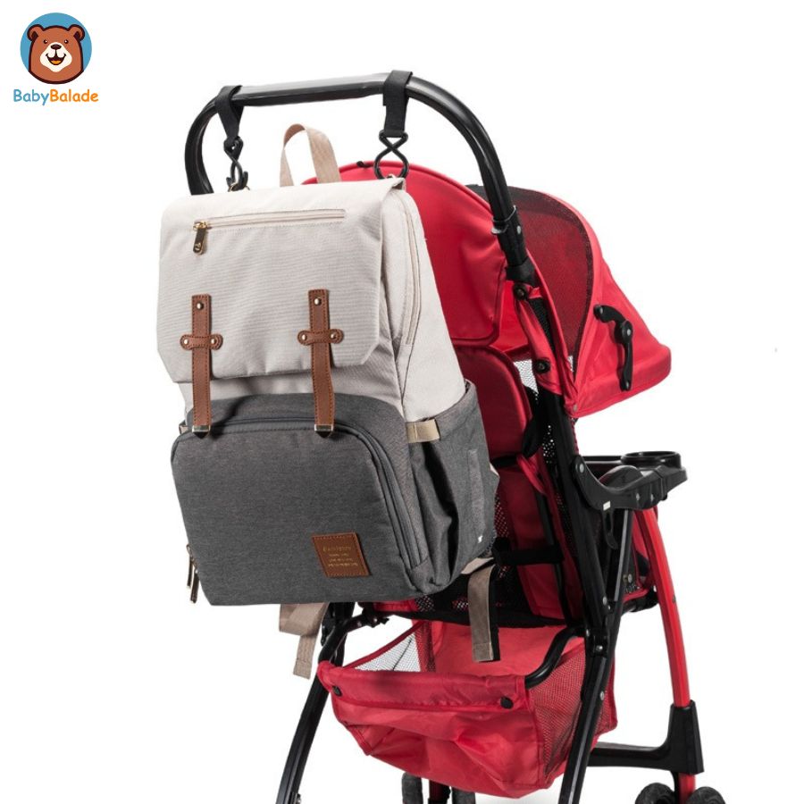 sac à dos à langer de couleur crème accroché à la poussette